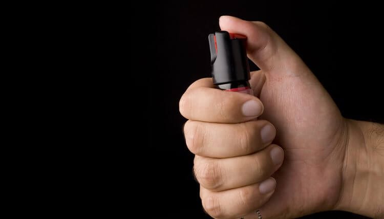 Hand holding pepper spray ready to use it