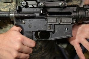 Man in camo holding a firearm closeup