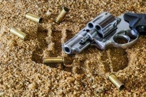 Gun in the sand surrounded by shells