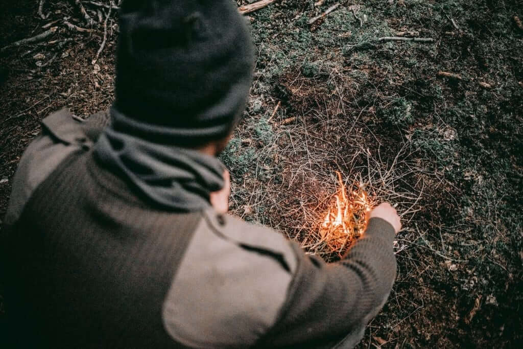 Man starting a fire outdoors