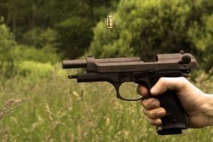 Closeup of man's hand shooting gun out in wilderness